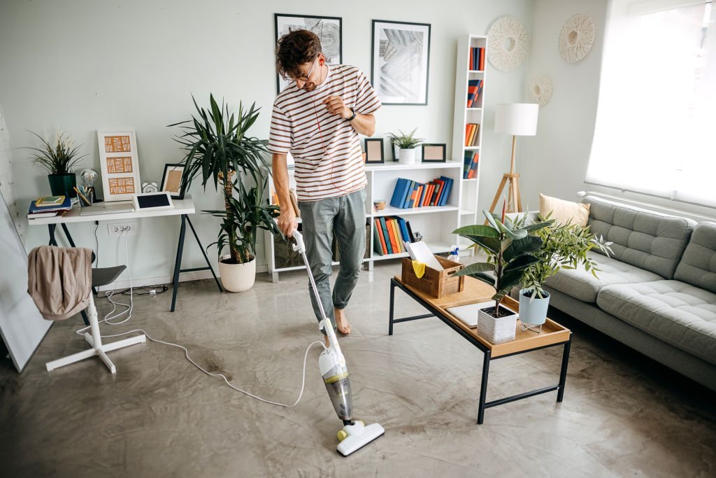 Man Cleaning House With Wireless Vacuum Cleaner, Making Housework Alone